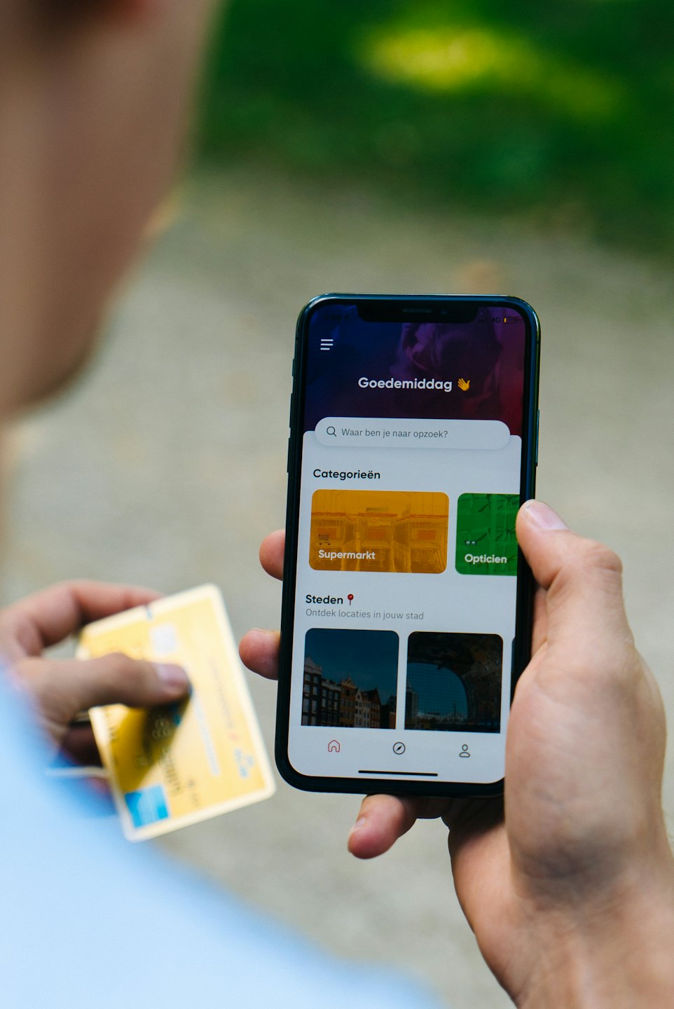 Hands holding a smartphone showing local business search.